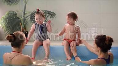 两个婴儿在水池里笑，跳到水里拍手